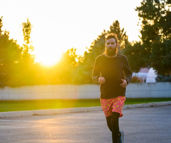Silhouette of a man stretching against a sunrise, symbolizing energy and vitality.